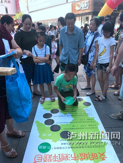 市民在宣傳點(diǎn)參加創(chuàng)文趣味游戲。 記者 朱虹 攝